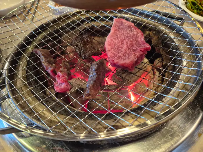 숯불 위에서 구워지고 있는 다양한 부위의 소고기
