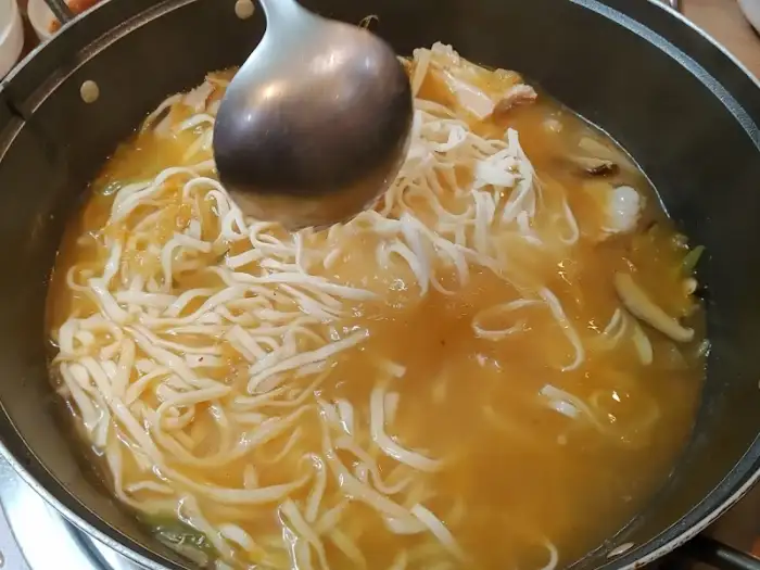 국물과 함께 끓고 있는 칼국수 면발