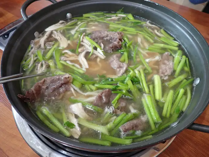 집게로 샤브샤브 재료를 집는 모습