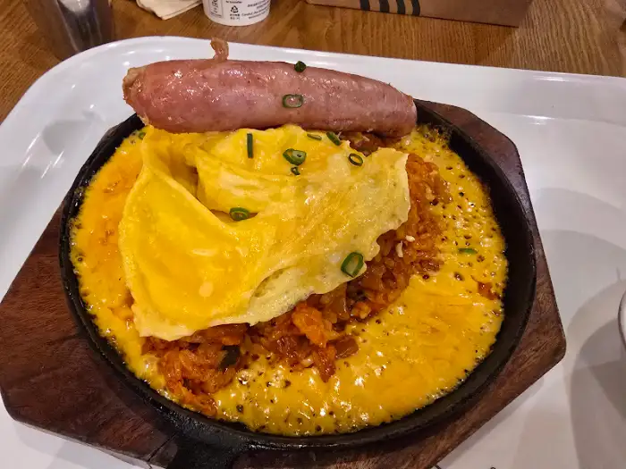 김치볶음밥 위에 소시지와 계란이 올라간 모습