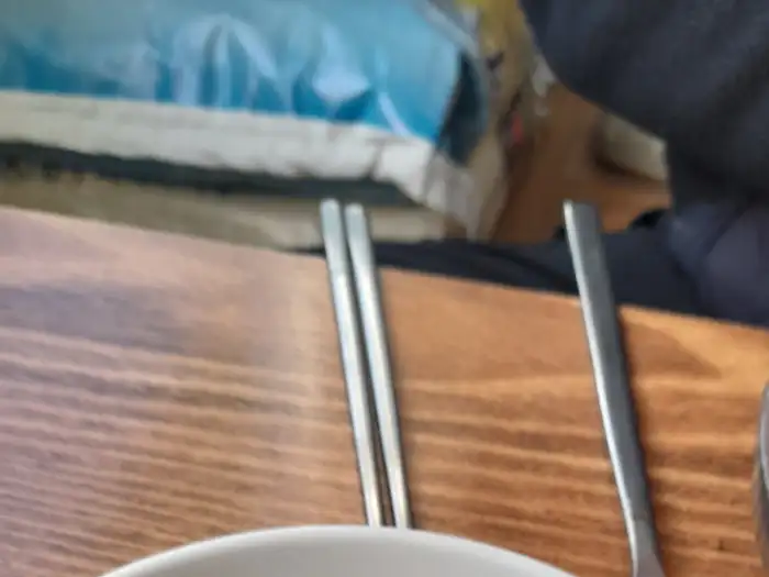 나무 테이블 위에 놓인 놋수저와 젓가락