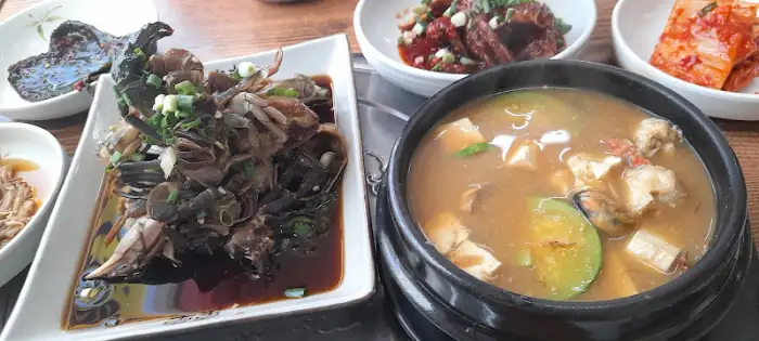 김이 모락모락 나는 된장찌개와 그 옆으로 준비된 반찬들