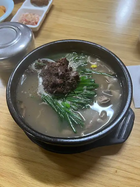 암뽕순대와 국물이 함께 담긴 국밥. 짙은 색의 순대와 맑은 국물이 대비된다.