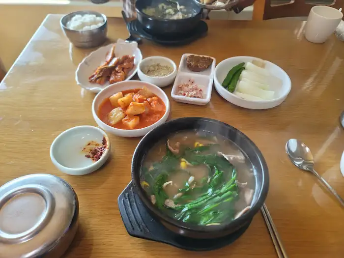 테이블에 차려진 다양한 반찬과 국밥. 푸짐한 한 상이 먹음직스럽다.
