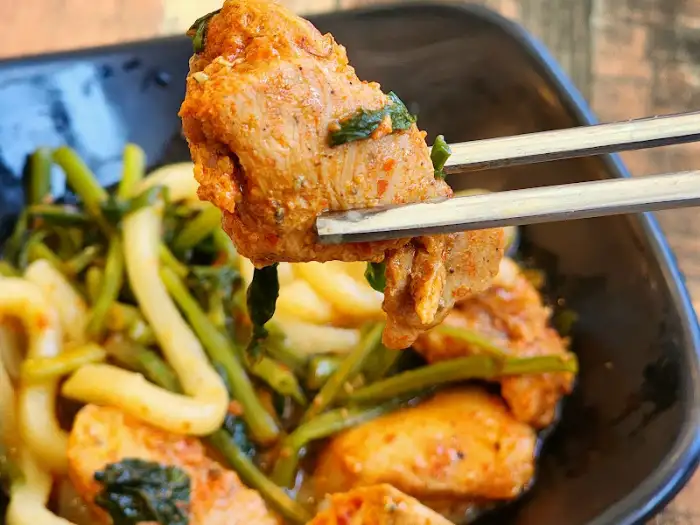 집게로 집어 올린 닭갈비 조각