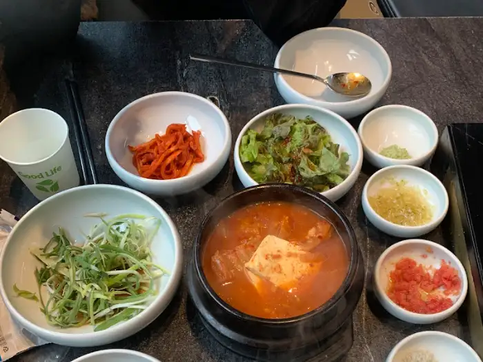 얼큰한 김치찌개와 밥, 그리고 각종 반찬들이 차려진 모습
