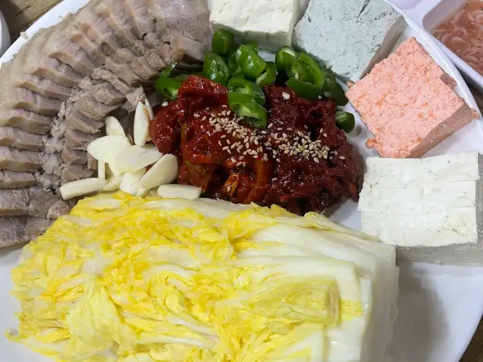 수육, 삼색 두부, 쌈채소, 곁들임 양념 등이 플레이팅된 모습