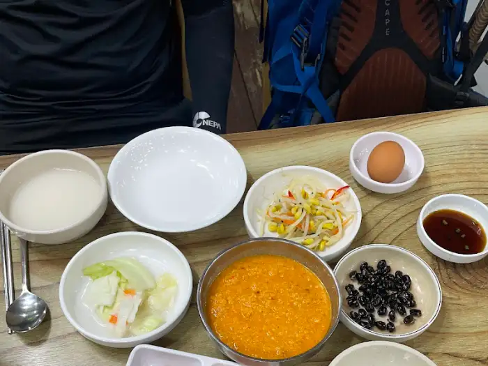 다양한 곁들임 반찬과 밥, 양념장 등이 놓인 테이블 모습