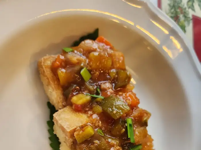 바삭하게 구운 빵 위에 다진 채소와 소스가 얹어진 요리. 든든하고 맛깔스러워 보입니다.