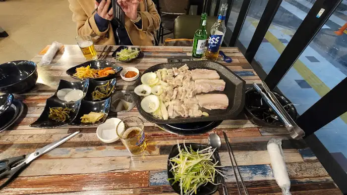 테이블에 놓인 삼겹살과 곁들임 찬