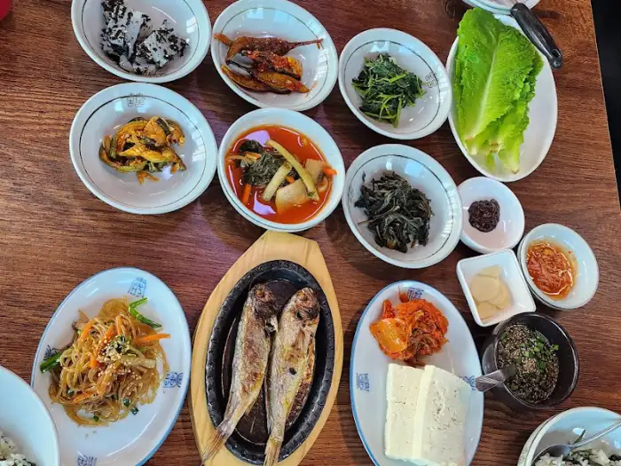 다양한 나물 반찬과 생선구이, 수육 등이 차려진 한상차림