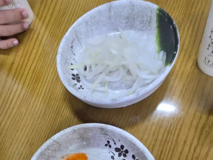 하얀 양파 채가 담긴 작은 접시.