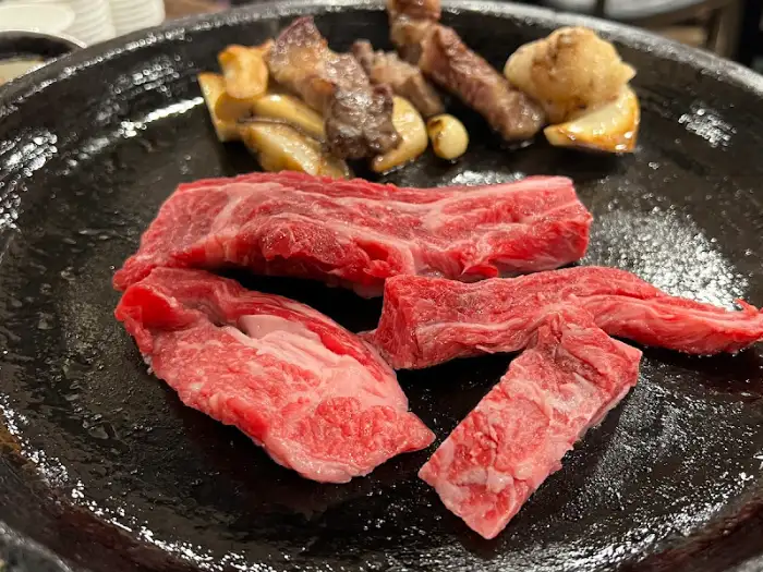 불판 위에 올려진 한우와 버섯, 마늘