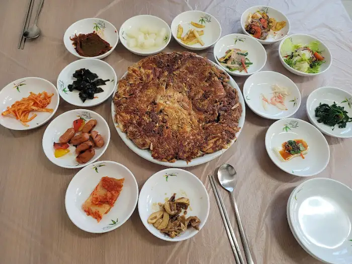정갈하게 차려진 촌닭양념구이와 버섯전골, 그리고 다채로운 밑반찬 모습