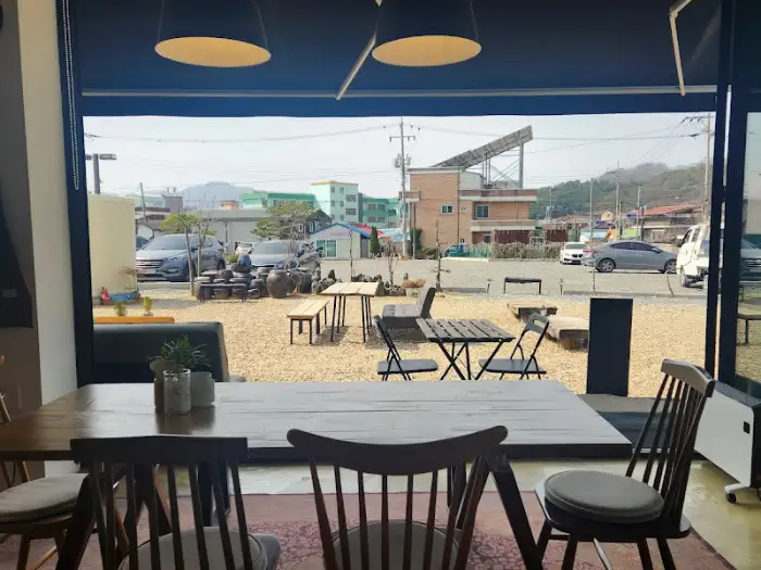카페에서 바라본 바깥 풍경 - 건물과 나무, 도로 등이 보이는 모습