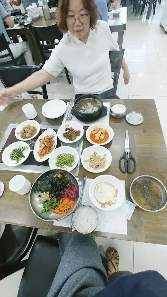 테이블에 차려진 정갈한 한상차림, 비빔밥과 갈비탕이 보인다.