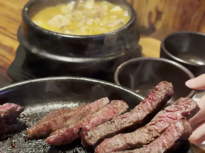 계란찜이 둘러진 불판 위에서 익어가는 한우와 된장찌개