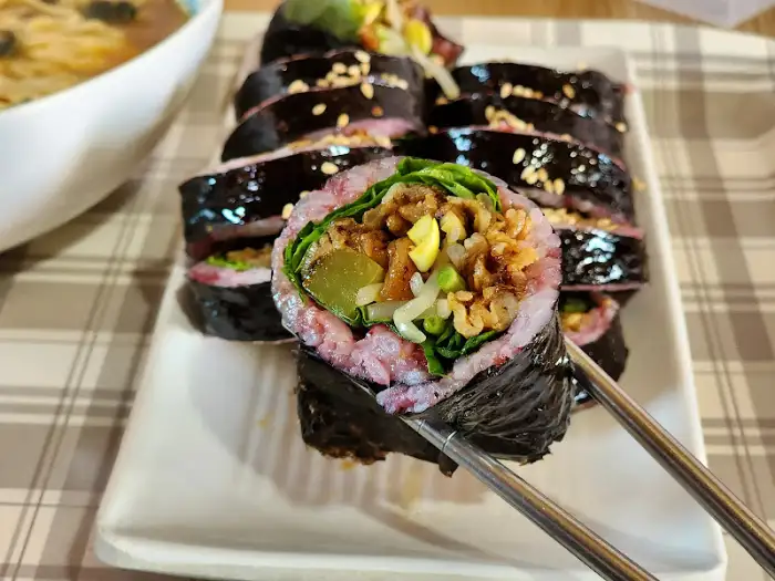 김밥 한 조각을 집어 올린 모습