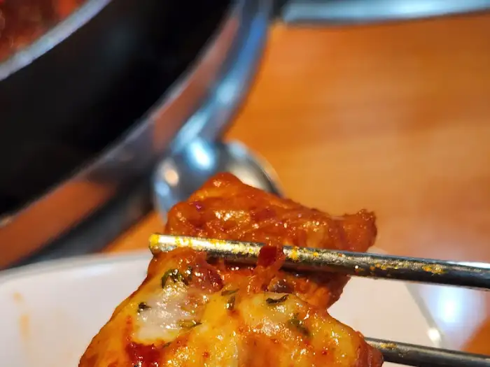 젓가락으로 집어 올린 닭갈비 조각