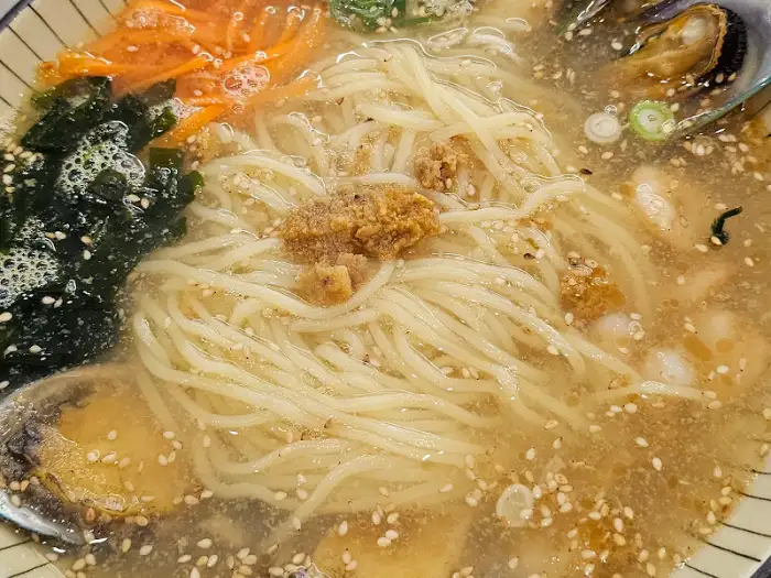고기국수 클로즈업 사진. 면발과 국물, 그리고 고명이 먹음직스럽게 담겨 있다.