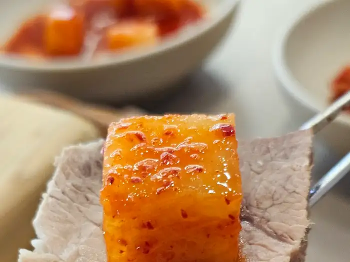 돔베고기 한 점에 김치가 올라간 모습. 수육의 촉촉함과 김치의 빛깔이 선명하다.