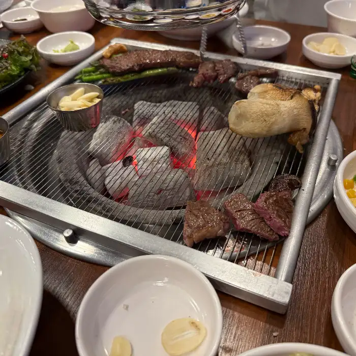숯불 위에서 구워지는 한우와 버섯
