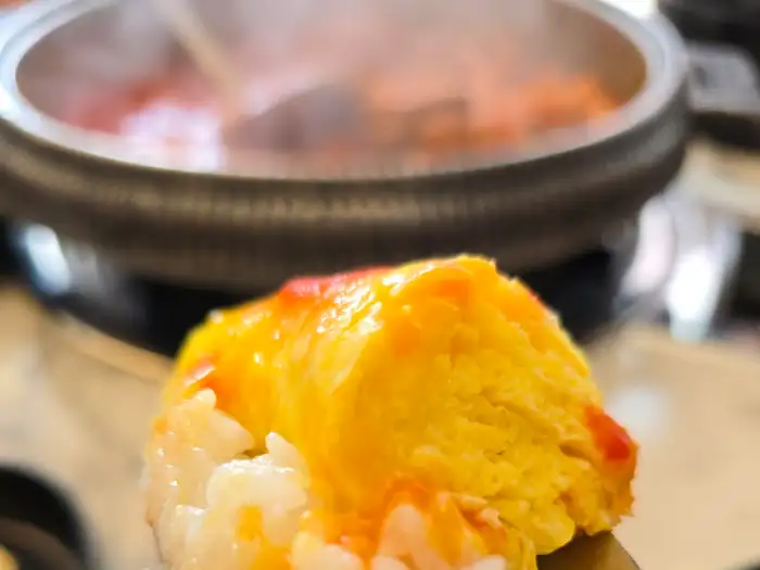 밥 위에 올려진 푸짐한 계란말이 한 조각