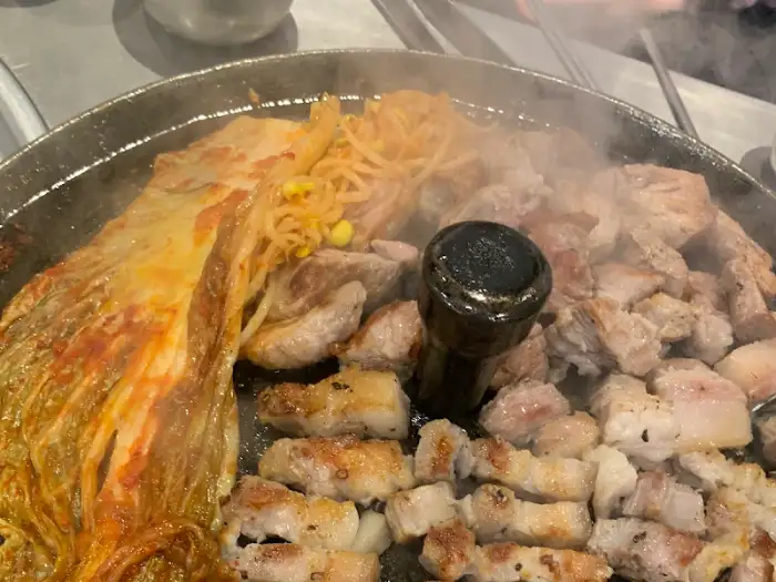 불판에 올려진 삼겹살, 김치, 콩나물