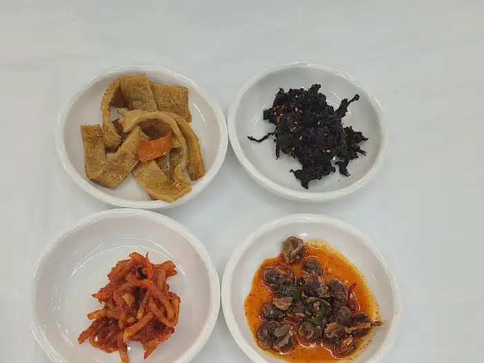 네 가지 맛깔스러운 반찬이 작고 귀여운 그릇에 담겨 있습니다.
