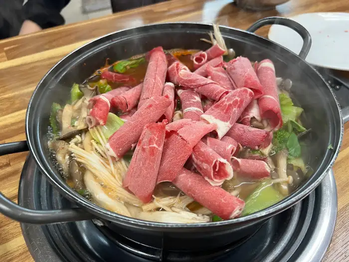 신선한 야채와 얇게 썬 소고기가 푸짐하게 담긴 샤브샤브 냄비