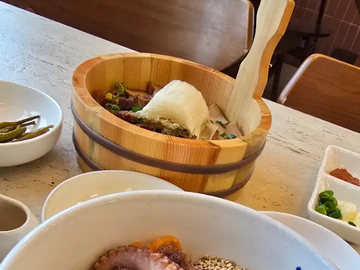 나무 통에 담긴 수육과 쌈 채소