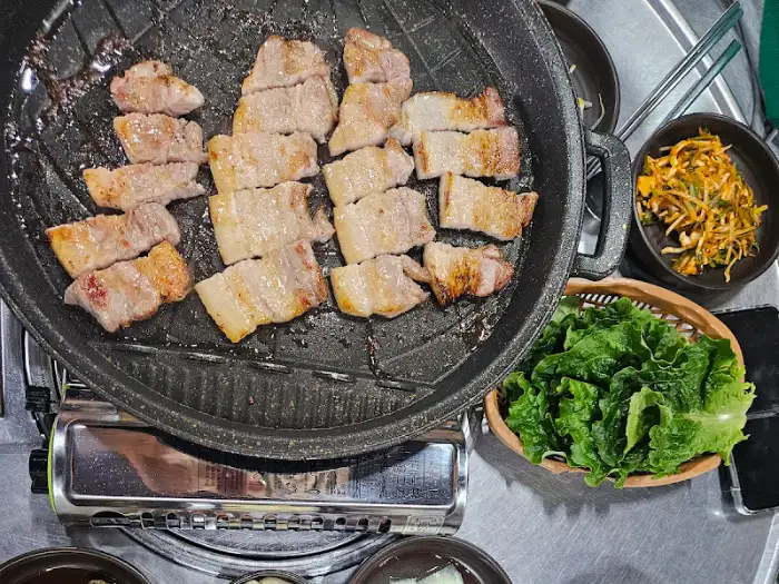 테이블에서 구워지는 삼겹살과 반찬