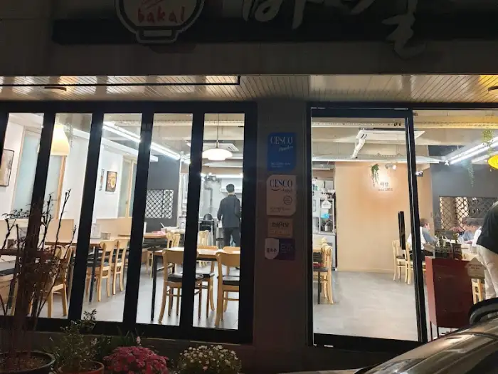 식당 외관 모습, 저녁 시간에 조명이 켜져 있습니다.