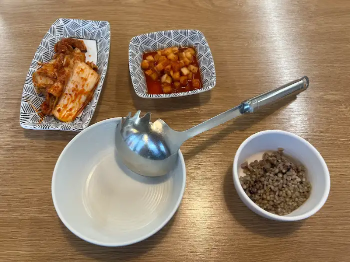 반찬과 국자, 보리밥이 담긴 그릇들.