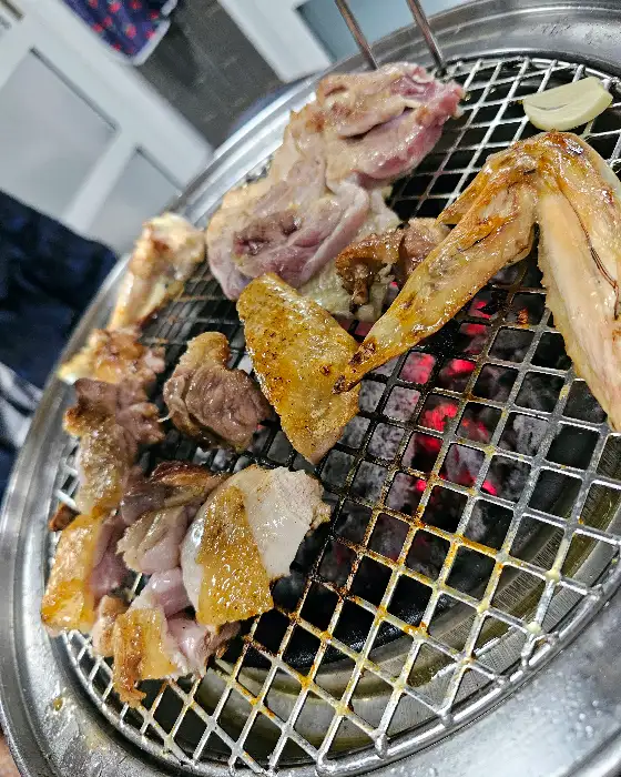 숯불 위에서 맛있게 구워지고 있는 닭고기 조각들