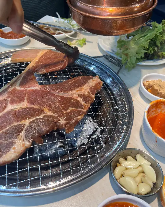 두툼한 고기가 숯불 위에서 익어가고 있다.