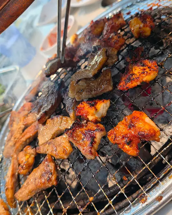 다양한 고기 부위가 숯불 위에서 노릇하게 구워지고 있다.