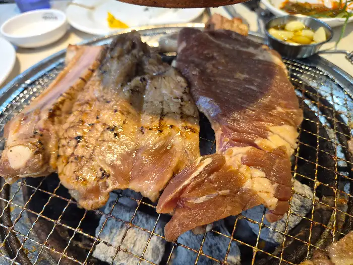 숯불 위에서 익어가고 있는 다양한 고기 조각들