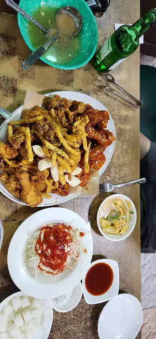 음식 사진 6: 테이블에 차려진 다양한 음식들, 치킨, 샐러드, 소스, 음료수 등