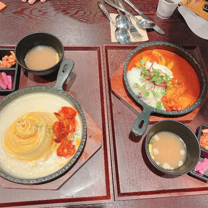 철판에 담겨 나온 카레와 오므라이스, 그리고 곁들임 반찬