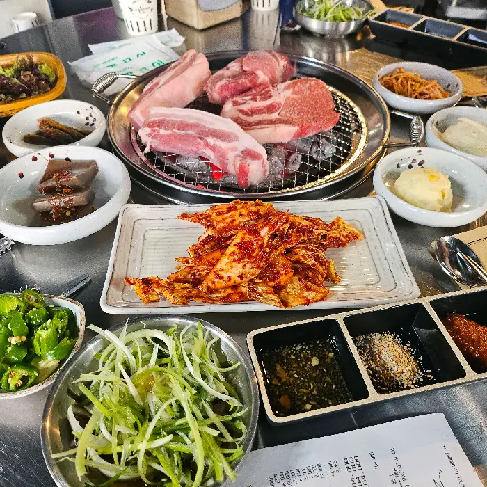 두툼한 목살과 삼겹살이 숯불 위에 놓여 있습니다.