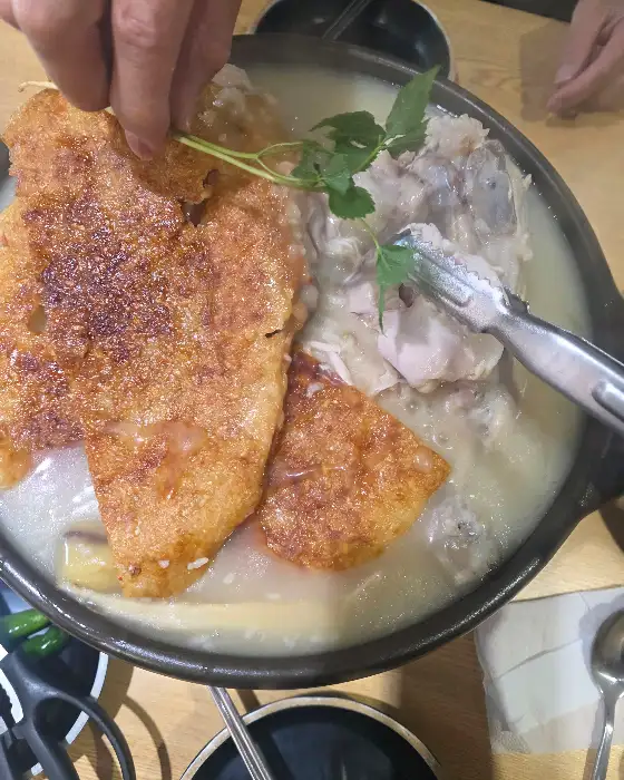 누룽지 아래 닭고기가 보이는 백숙 모습