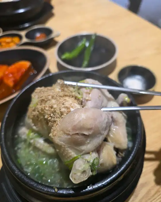 집게로 닭고기를 들어 올리는 모습