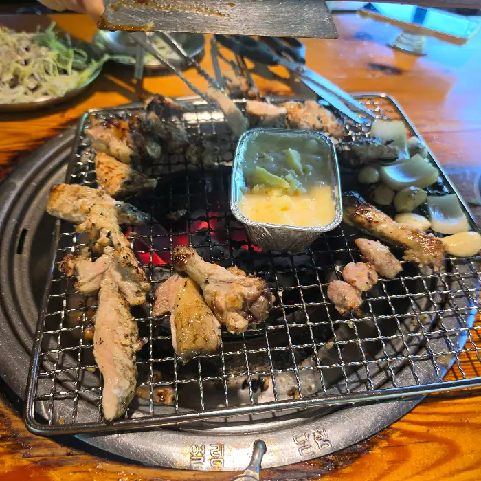 다양한 부위의 닭구이가 숯불 위에서 익고 있는 모습
