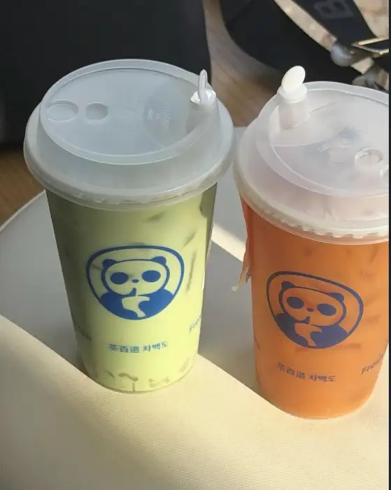 녹색과 주황색 음료가 담긴 두 개의 컵