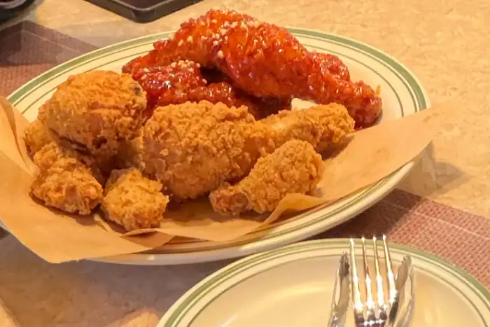 양념치킨과 후라이드 치킨이 함께 담긴 반반 메뉴. 두 가지 맛을 동시에 즐길 수 있어 만족스럽습니다.