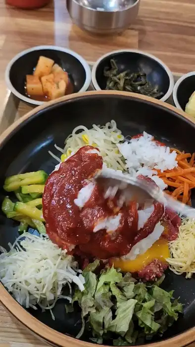 비빔밥에 고추장 소스를 넣고 비비는 모습