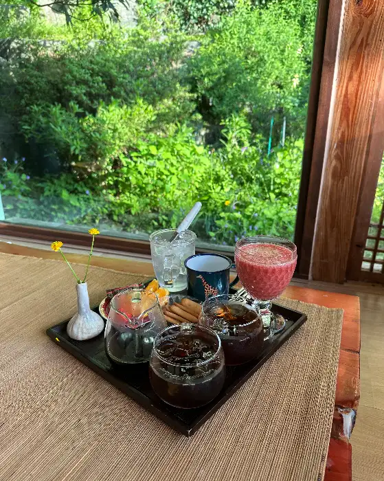 창가 자리에서 바라본 정원 풍경과 음료