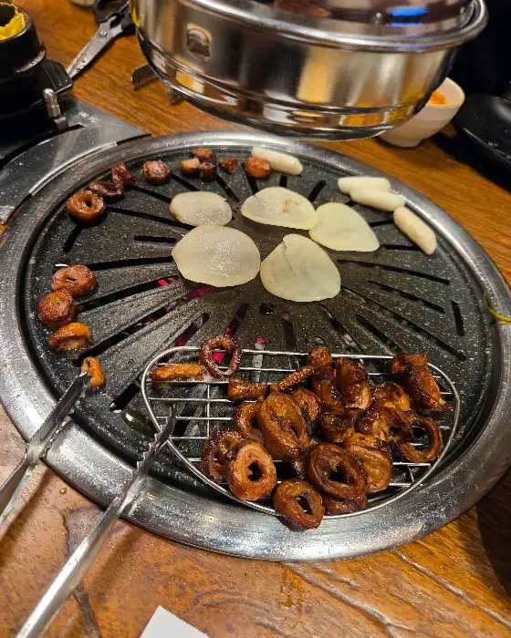 잘 구워진 막창을 집게로 집고 있는 모습