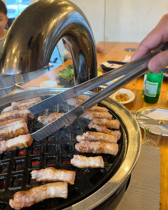 집게로 고기를 뒤집는 모습